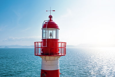 Investing cash solutions, image of red and white light house