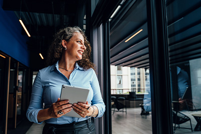 Cross border considerations, women holding a tablet in an office