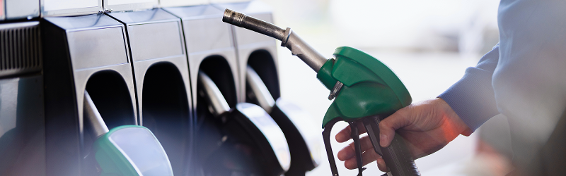 Image shows a person putting a petrol pump back in its holder