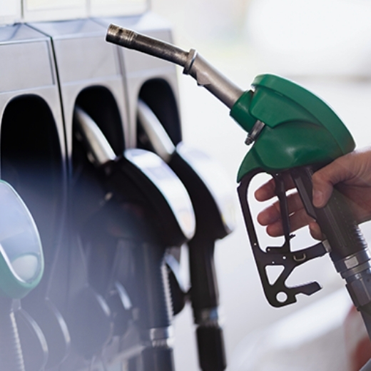 Image shows a person putting a petrol pump back in its holder