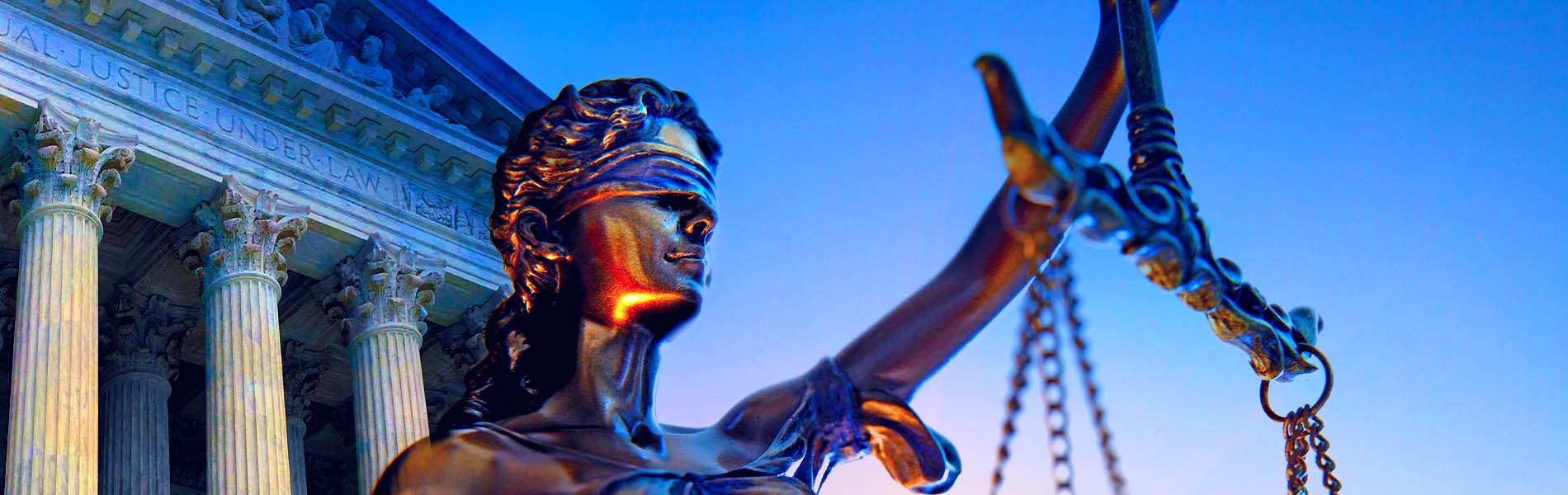 Image of Lady Justice statue outside courthouse against a blue sky
