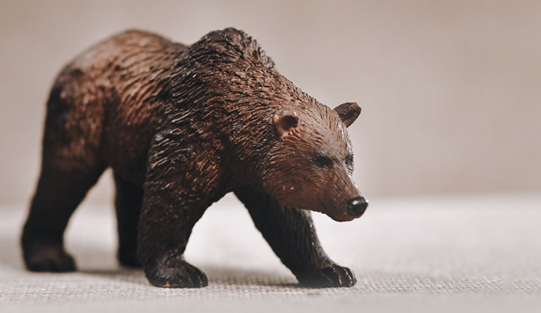 Image of a brown figurine bear positioned on the left of the banner looking towards the right