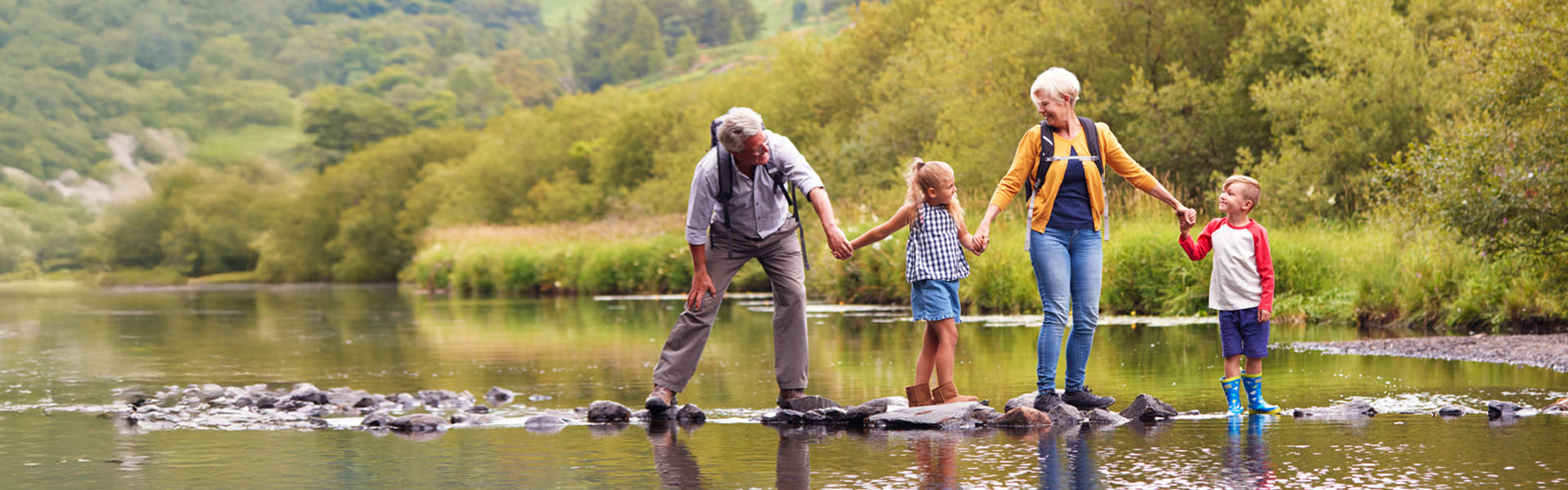 Grandparents walking on stepping stones with grandchildren