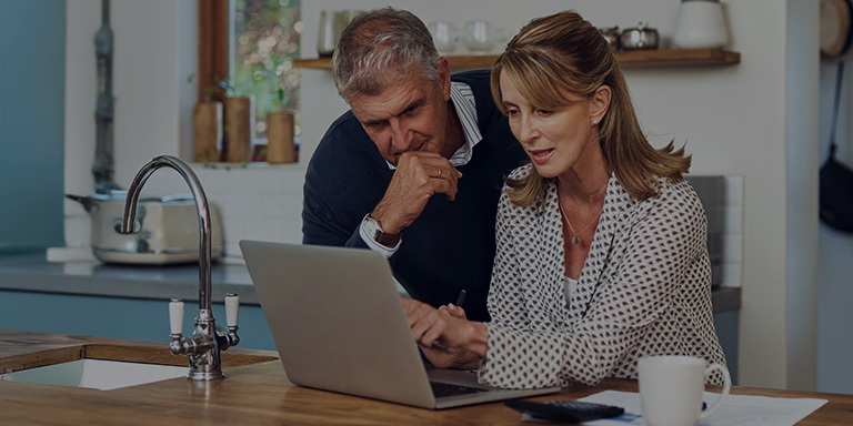 Man and woman looking at finances on laptop