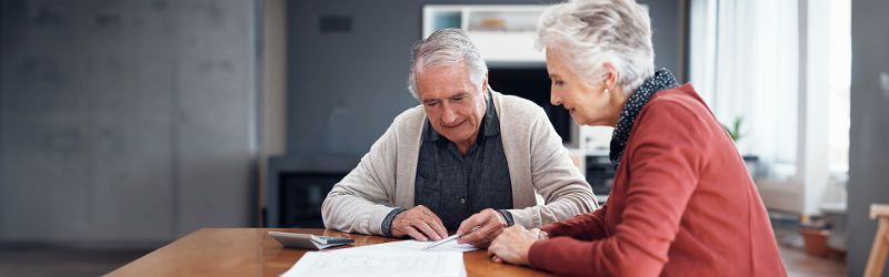 An elderly couple working through their financial paperwork