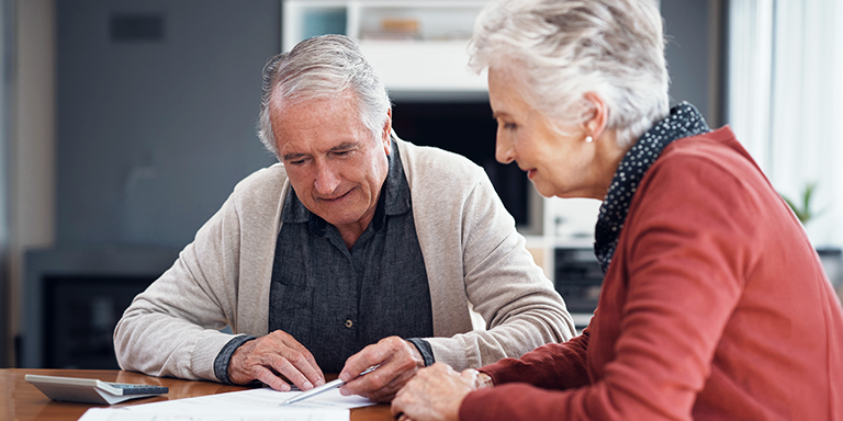 An elderly couple working through their financial paperwork